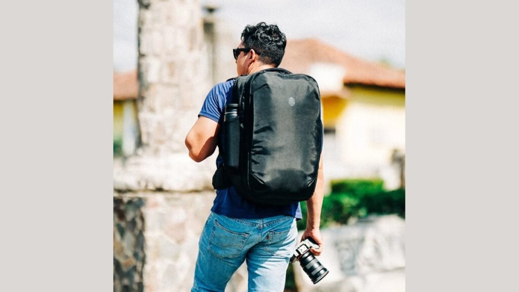 A modern traveler with a travel backpack waiting at a train station platform.