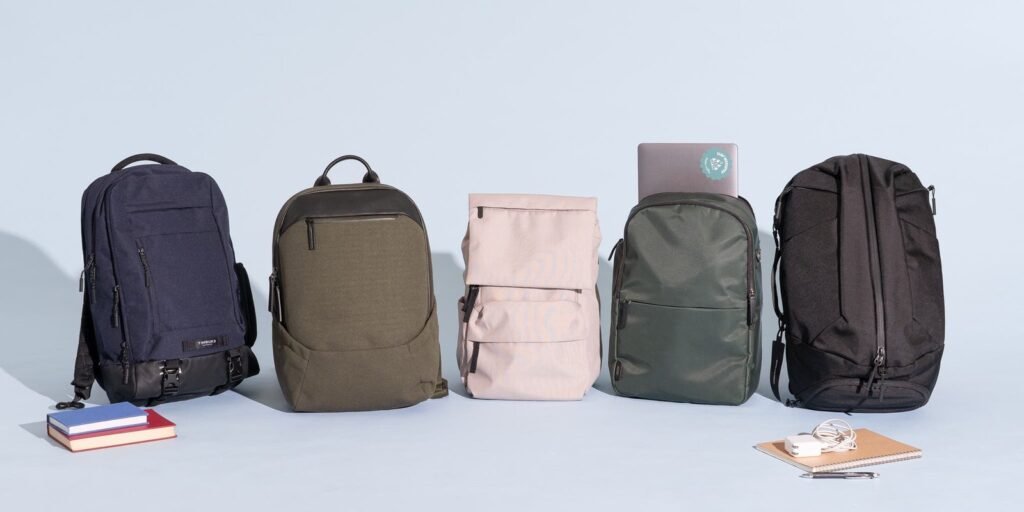 A stylish laptop backpack sits on a table in a bright, modern cafe.