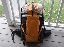 A hiking backpack being measured against a standard airline carry on size guide frame.