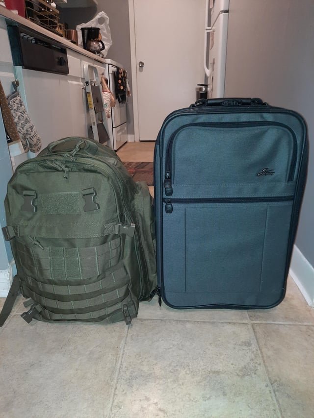 A traveler waiting in an airport lounge with their carry-on luggage.