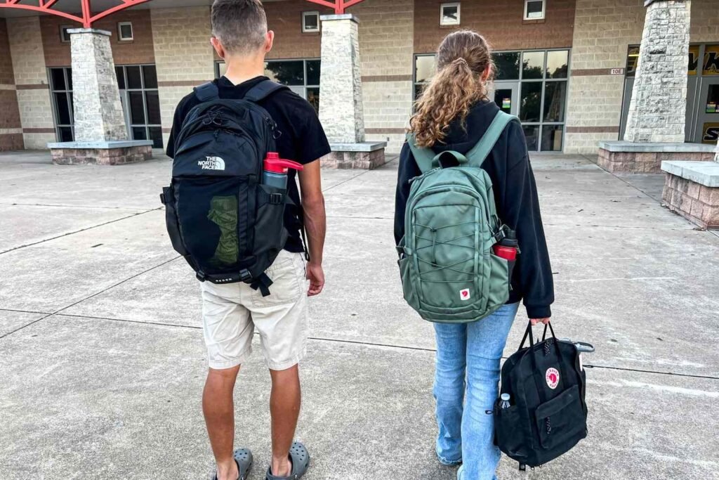 A durable and stylish backpack for high school students rests on a wooden bench.