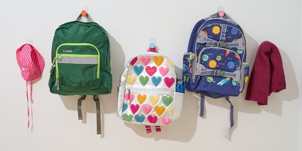 A happy child wearing a durable backpack while walking through a bright park.