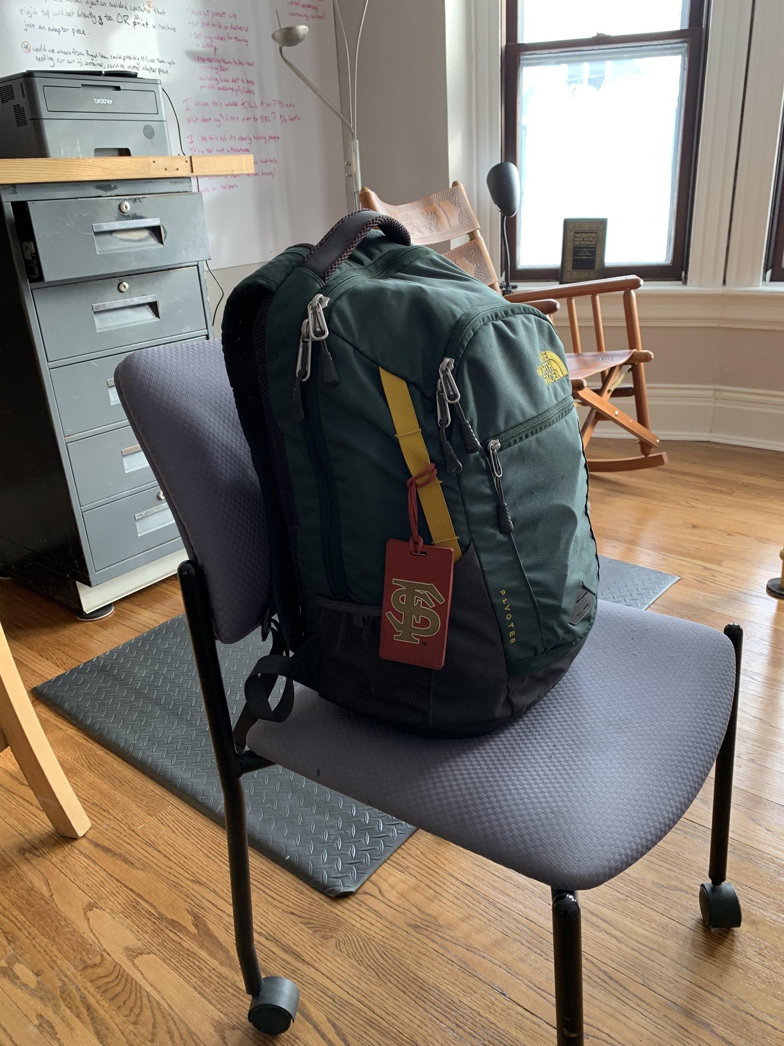 A travel backpack being measured for size inside an airport luggage sizer frame.