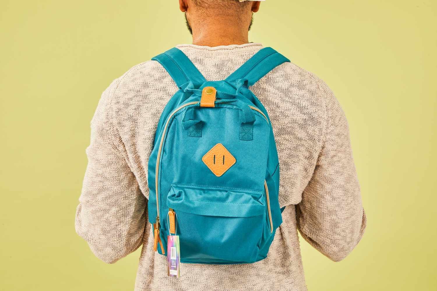 A person measuring a mini backpack to determine its capacity and proper fit.
