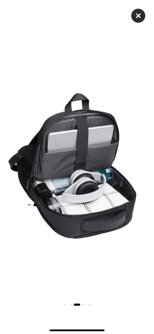 Carefully inserting a laptop into a protective sleeve inside a backpack.