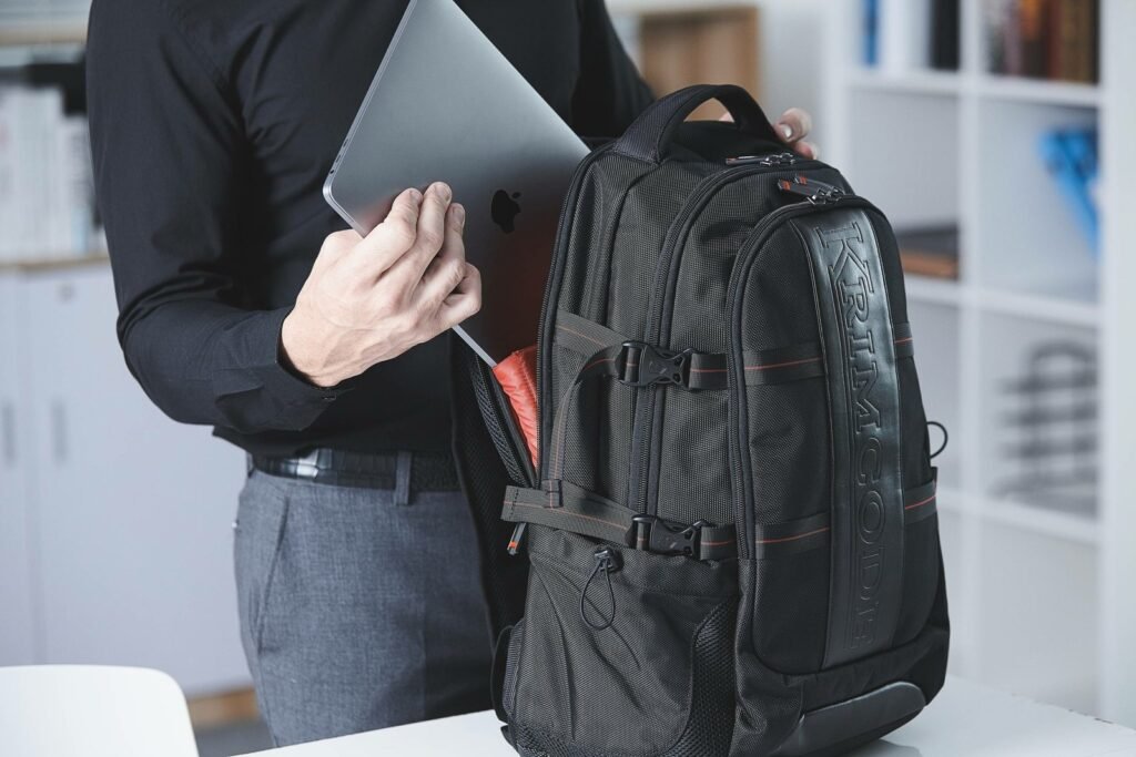 A professional laptop backpack resting on a wooden bench in a transit station.