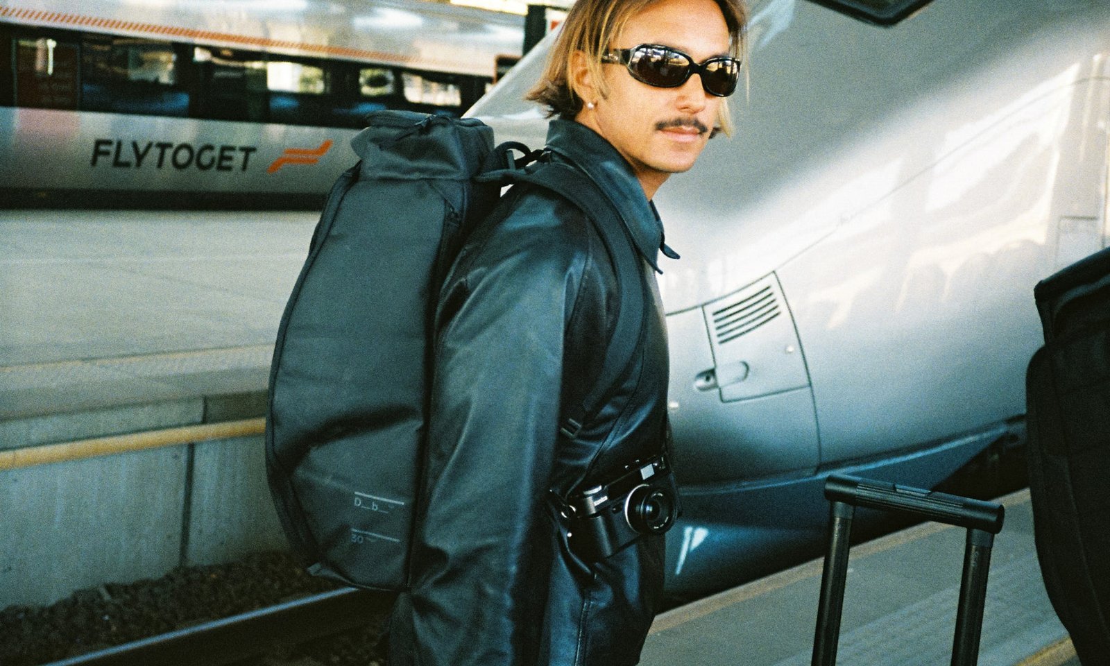 A close-up view of a travel backpack tag emphasizing quality and airline standards.