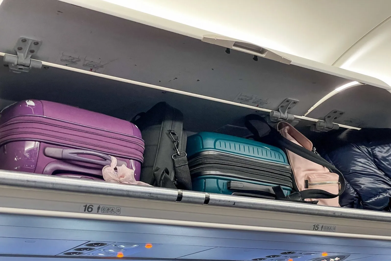 A passenger preparing for a flight with their carry-on and personal backpack.