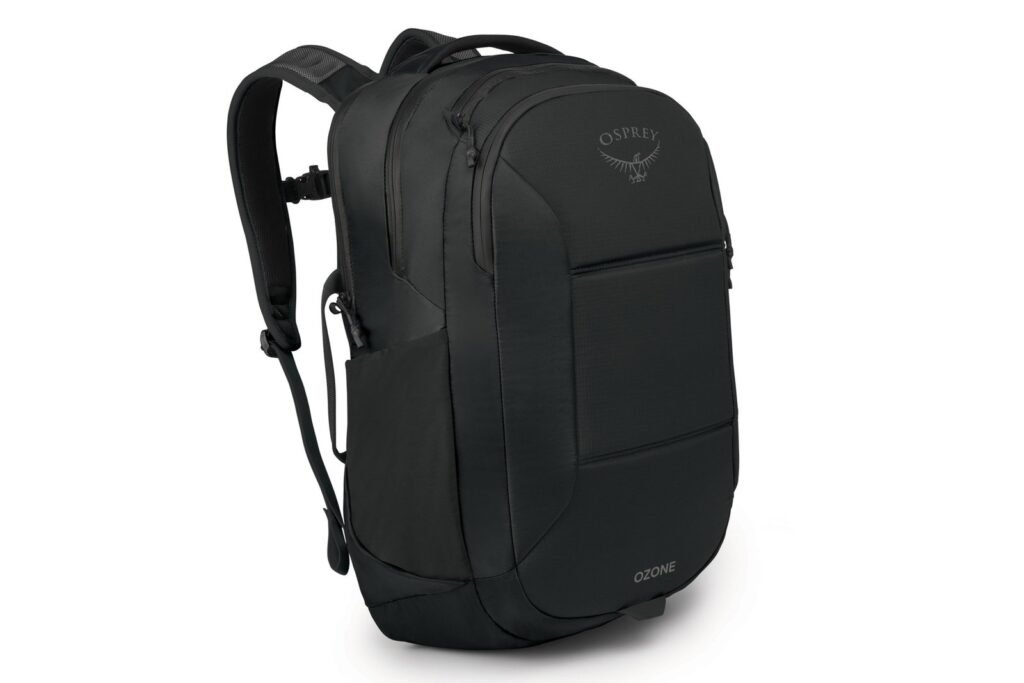 A stylish travel backpack for laptops resting on a wooden table in a cafe.