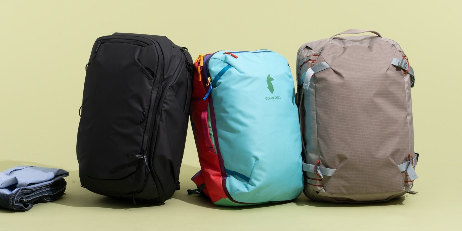 Three different sizes of travel backpacks displayed together to show capacity and style differences.
