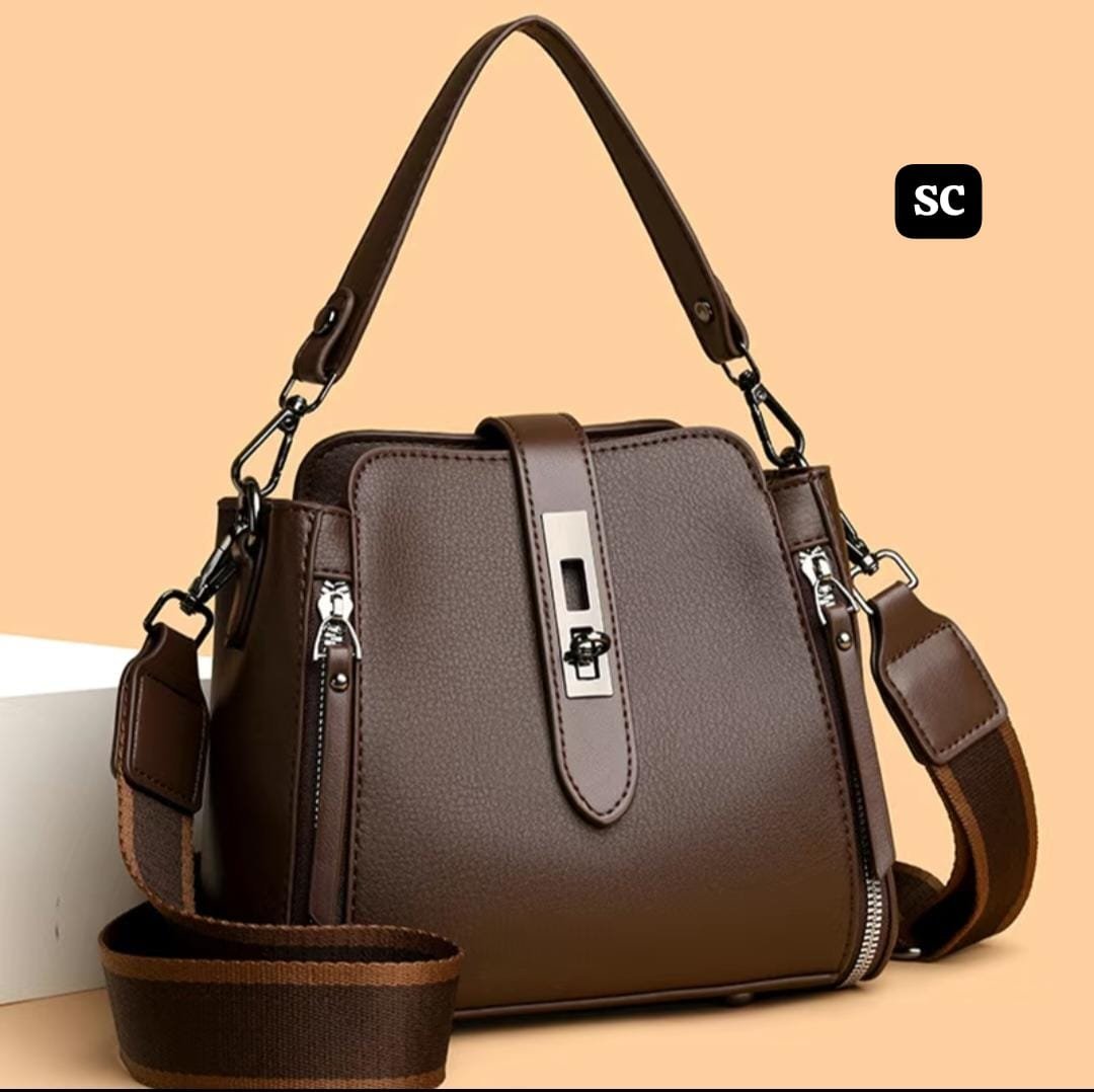 A damaged sling bag sitting on a dirty public floor showing signs of wear.