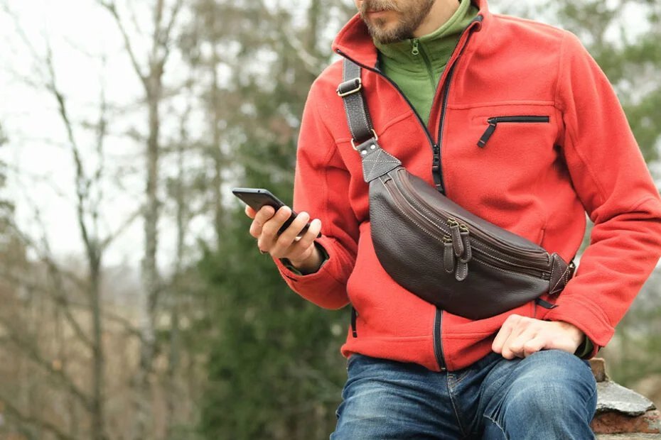 A person wears a sling purse across their chest for quick access.