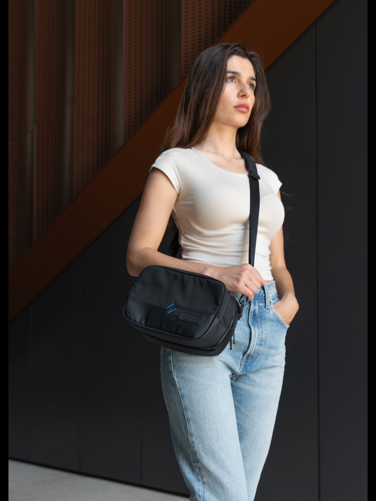A variety of sling purse designs hanging on a wall for easy selection.