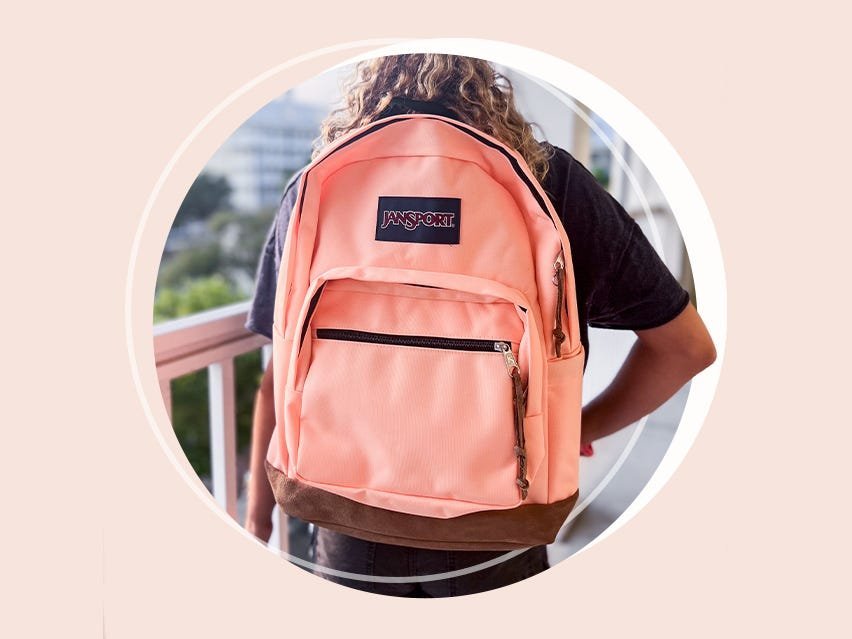 A close-up of a student adjusting the padded straps of a school backpack.