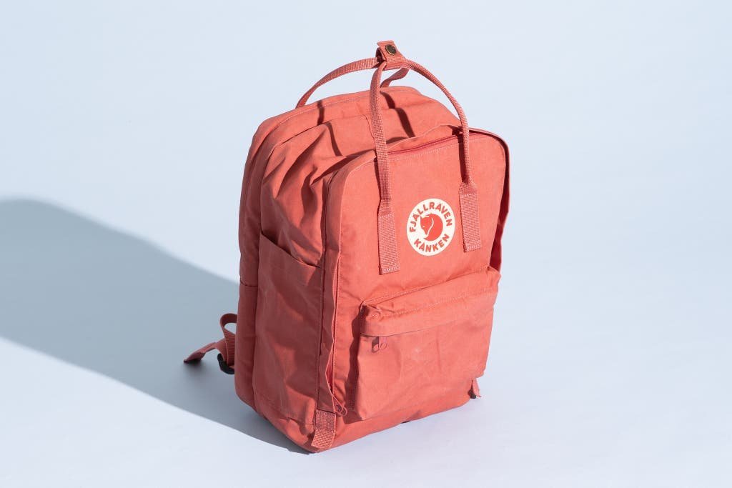 A durable backpack sits on a wooden desk as the best brand for school.