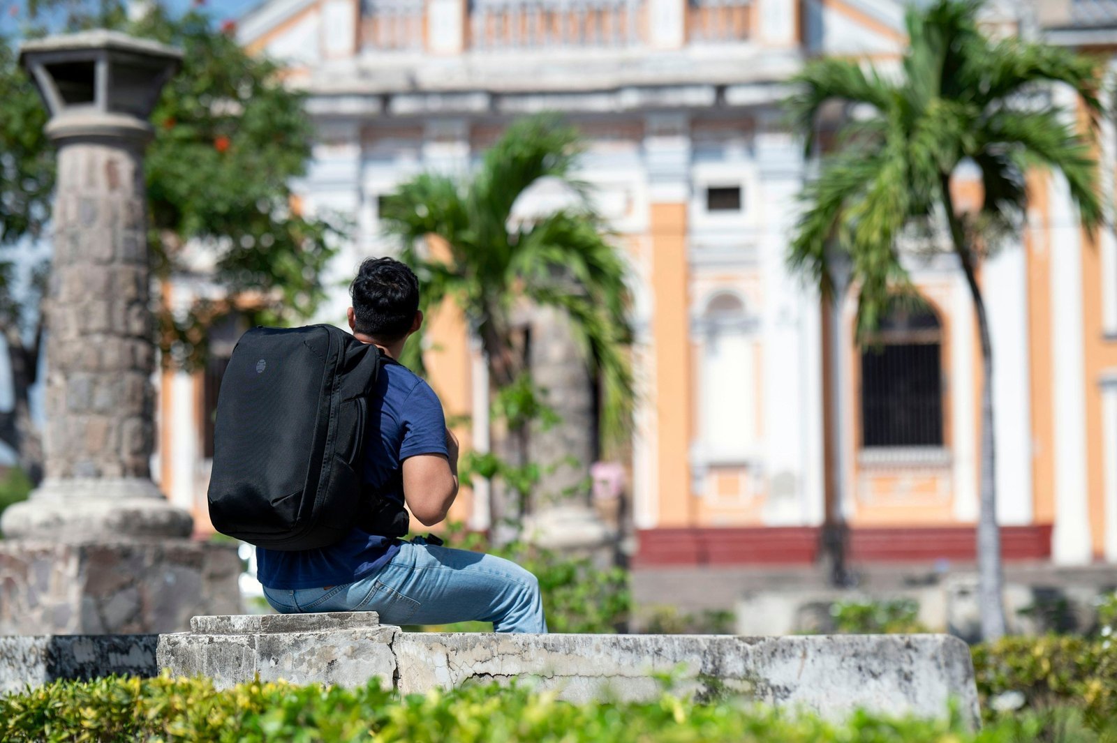 A traveler checking their packing list next to a well-organized travel backpack.