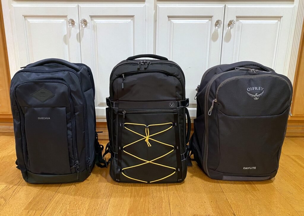 A modern travel backpack resting on a wooden bench at a train station.