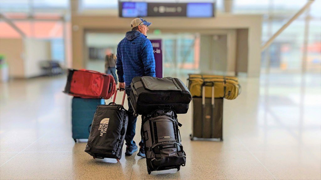 A backpack and a spinner suitcase waiting at a modern airport terminal.