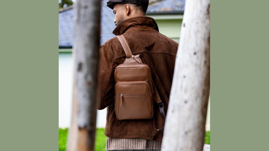 A modern small backpack sits on a concrete bench in an urban park.