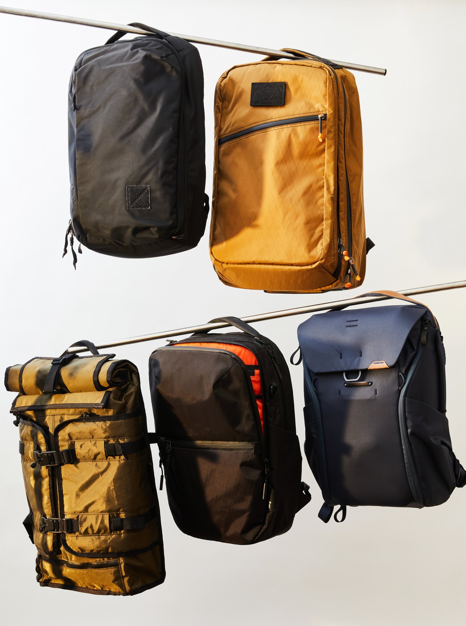 Various types of backpacks for hiking, commuting, and school laid out on a table.