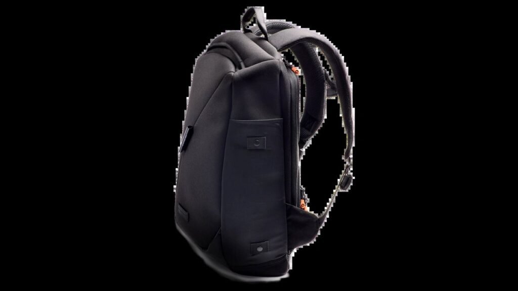 A stylish urban backpack sitting on a wooden bench in a city.