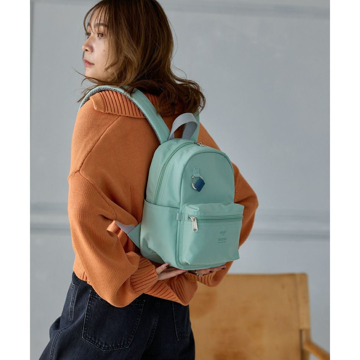A shopper looking at a wide selection of mini backpacks in a store.