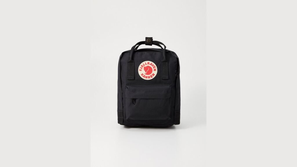 A variety of fashionable mini backpacks arranged on a minimalist store display.