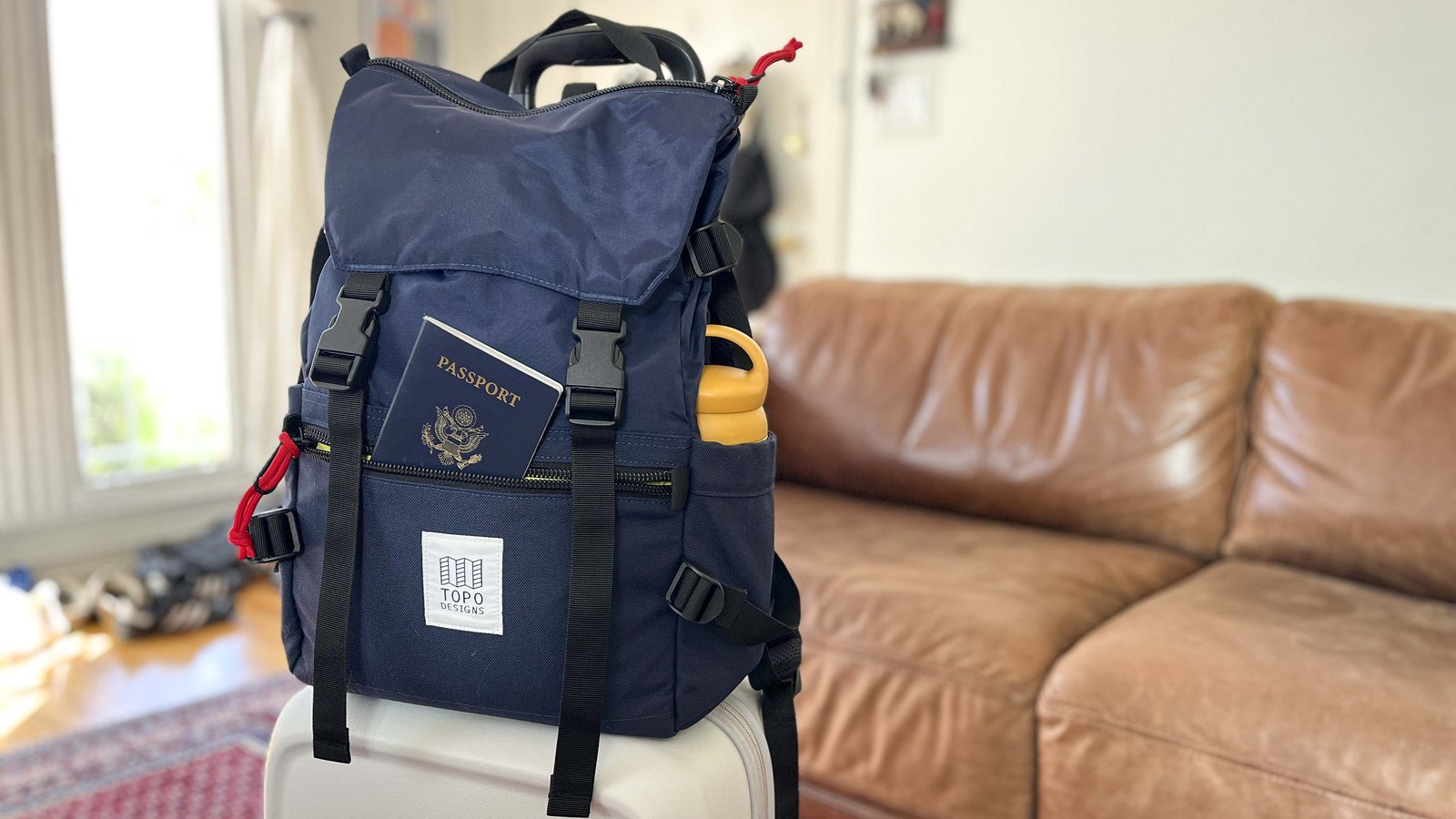 Hands adjusting the harness straps on a travel backpack for a comfortable fit.