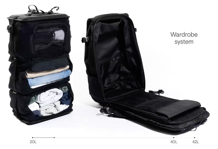 An organized travel backpack packed with essential gear on a wooden table.