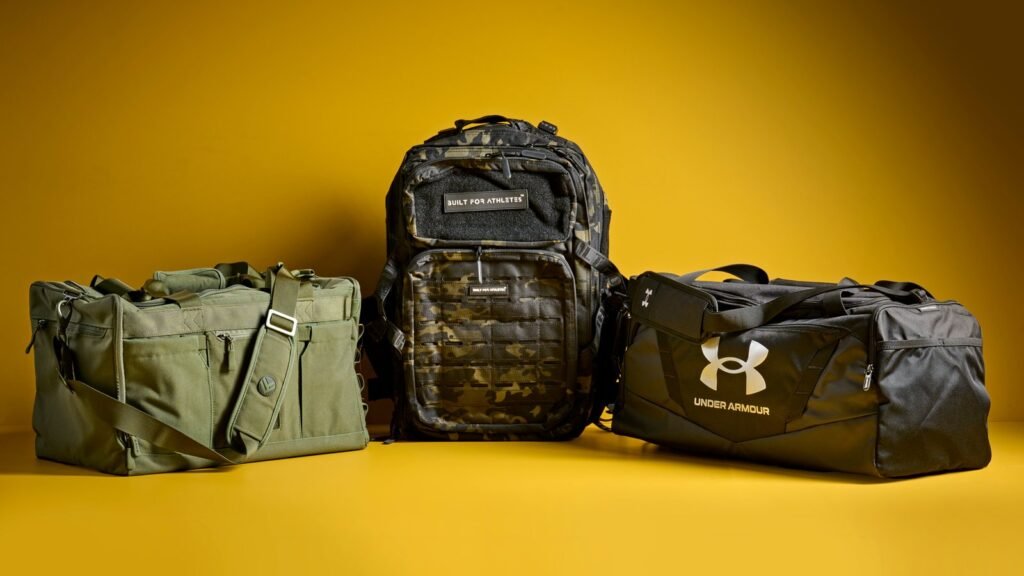 Black gym backpack on wooden bench beside towel and water bottle