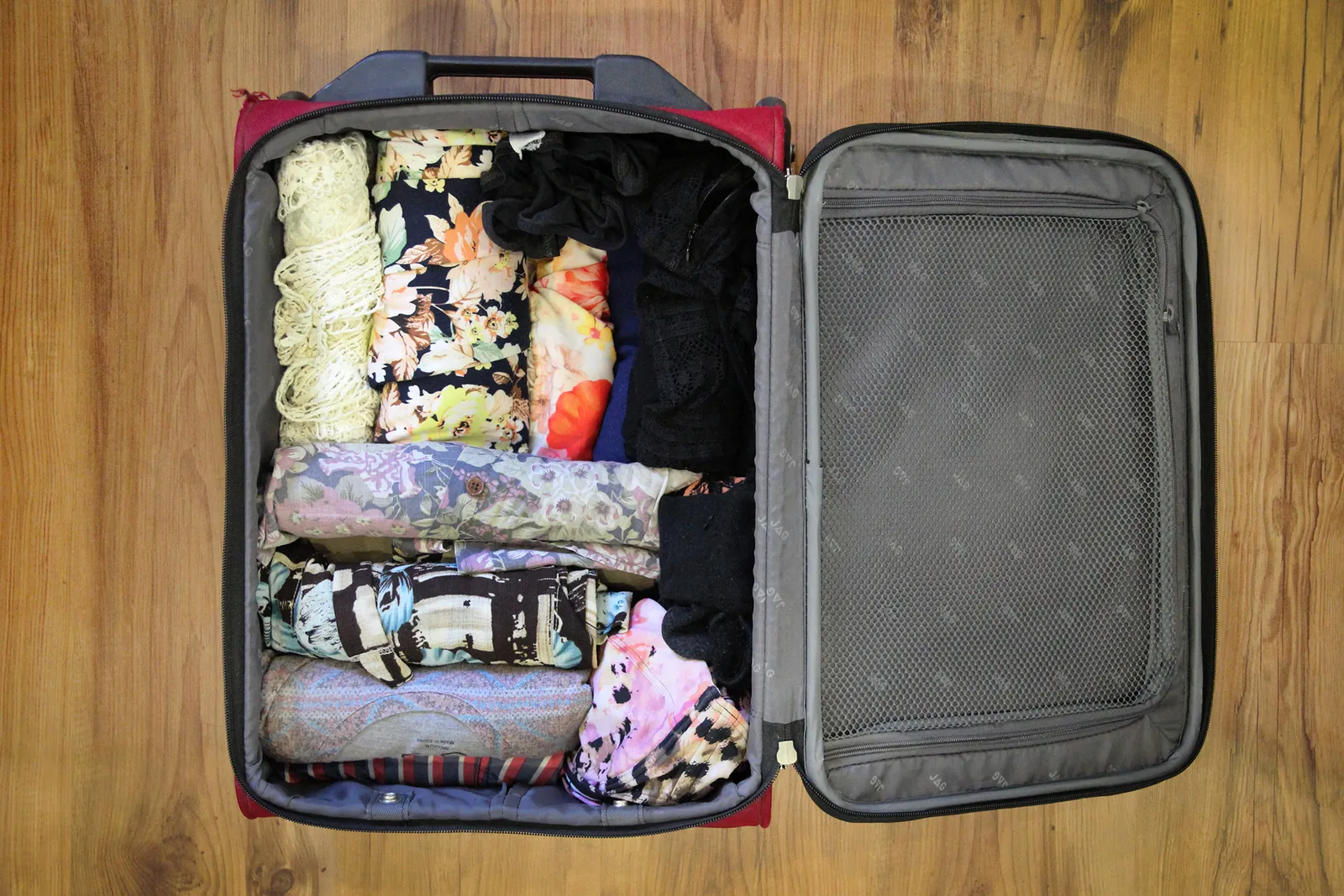 A carry-on suitcase and backpack stored correctly inside an airplane cabin.