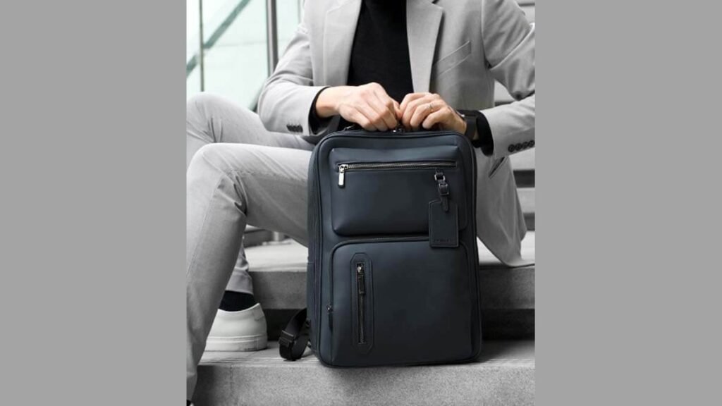Charcoal business backpack on wooden desk in sunlit modern office