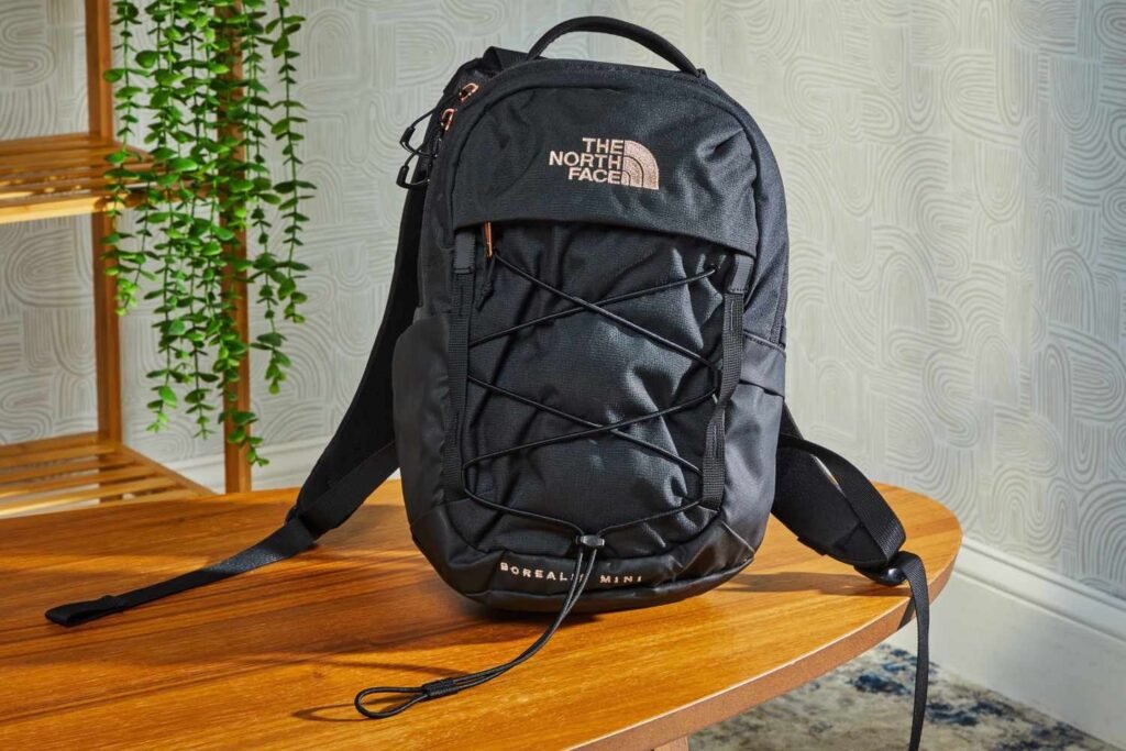 Durable travel backpack resting on wooden bench in sunlit airport terminal
