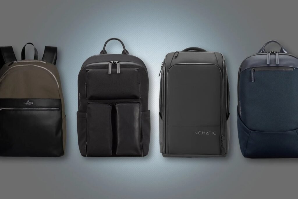 A professional business travel backpack sits on a bench in a modern airport lounge.