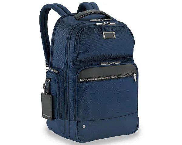A sleek charcoal gray work backpack stands in a modern office lobby.